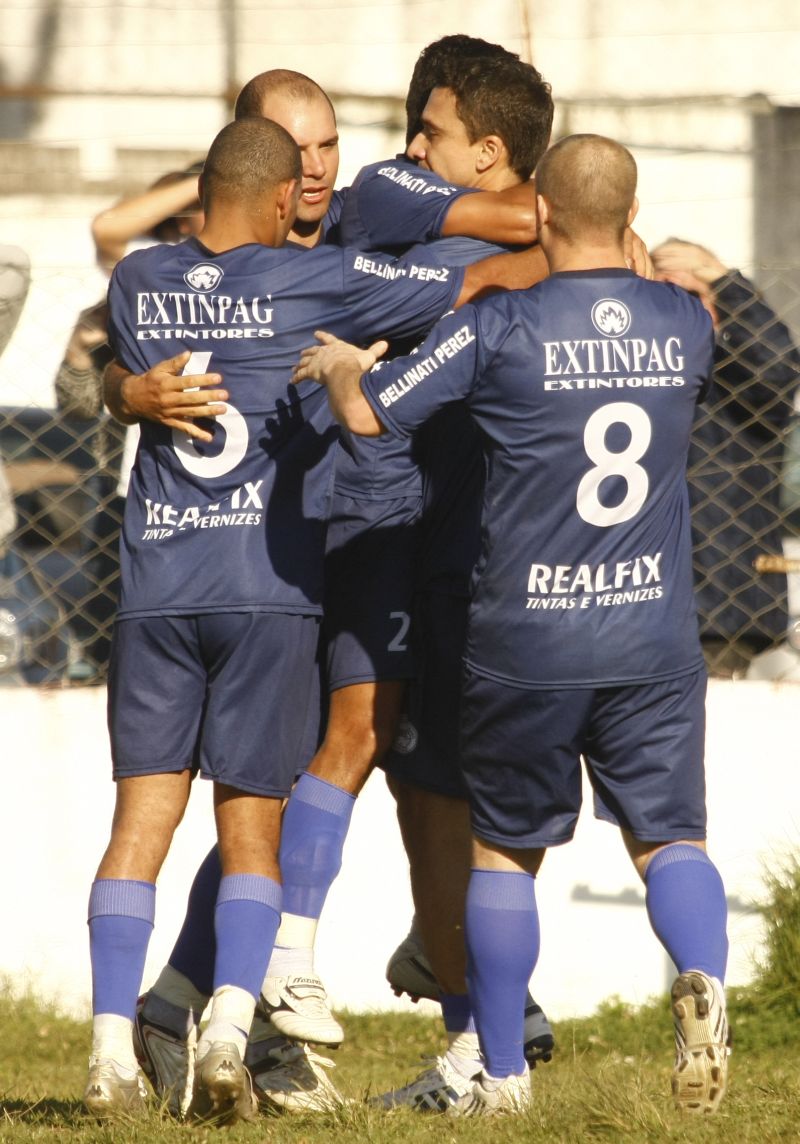 Laurinho (no meio da roda) comemora: Urano líder graças ao seu gol | Hugo Harada/Gazeta do Povo