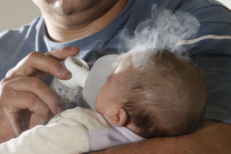 Anna Júlia, de 2 meses, já estava gripada, mas o tempo seco piorou a tosse e a dificuldade para respirar. Os pais Cleverson e Helena levaram a menina para fazer inalação | Antonio Costa / Gazeta do Povo