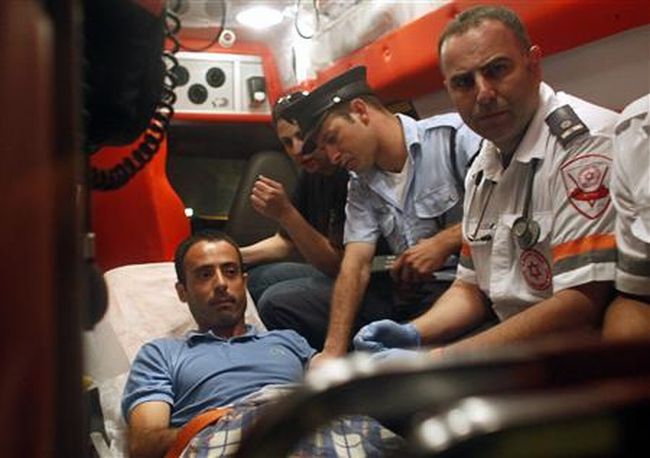 Médico israelense e policial acompanham o palestino Nadim Injas em uma ambulância, em Tel Aviv, Israel, nesta terça-feira. Injas foi ferido a tiros por seguranças depois de invadir a embaixada da Turquia e tomar reféns. O homem foi dominado e interrogado por diplomatas turcos durante mais de quatro horas | Reuters