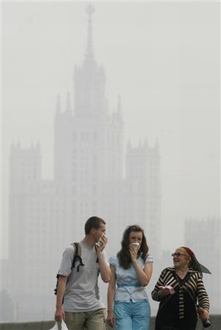 Pessoas cobrem o rosto ao caminhar sob fumaça intensa em Moscou. 09/08/2010 | REUTERS/Alex Aminev