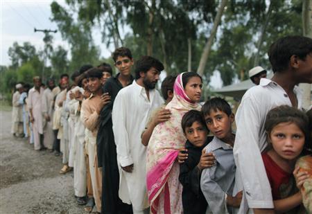 Vítimas de enchentes fazem fila para receber doações de alimentos perto de Nowshera, no noroeste do Paquistão, 18 de agosto de 2010 | REUTERS