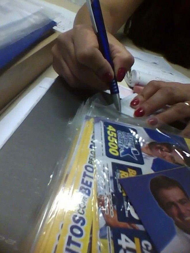 Funcionária entrega adesivos no gabinete de Felipe Braga Cortes | Reprodução