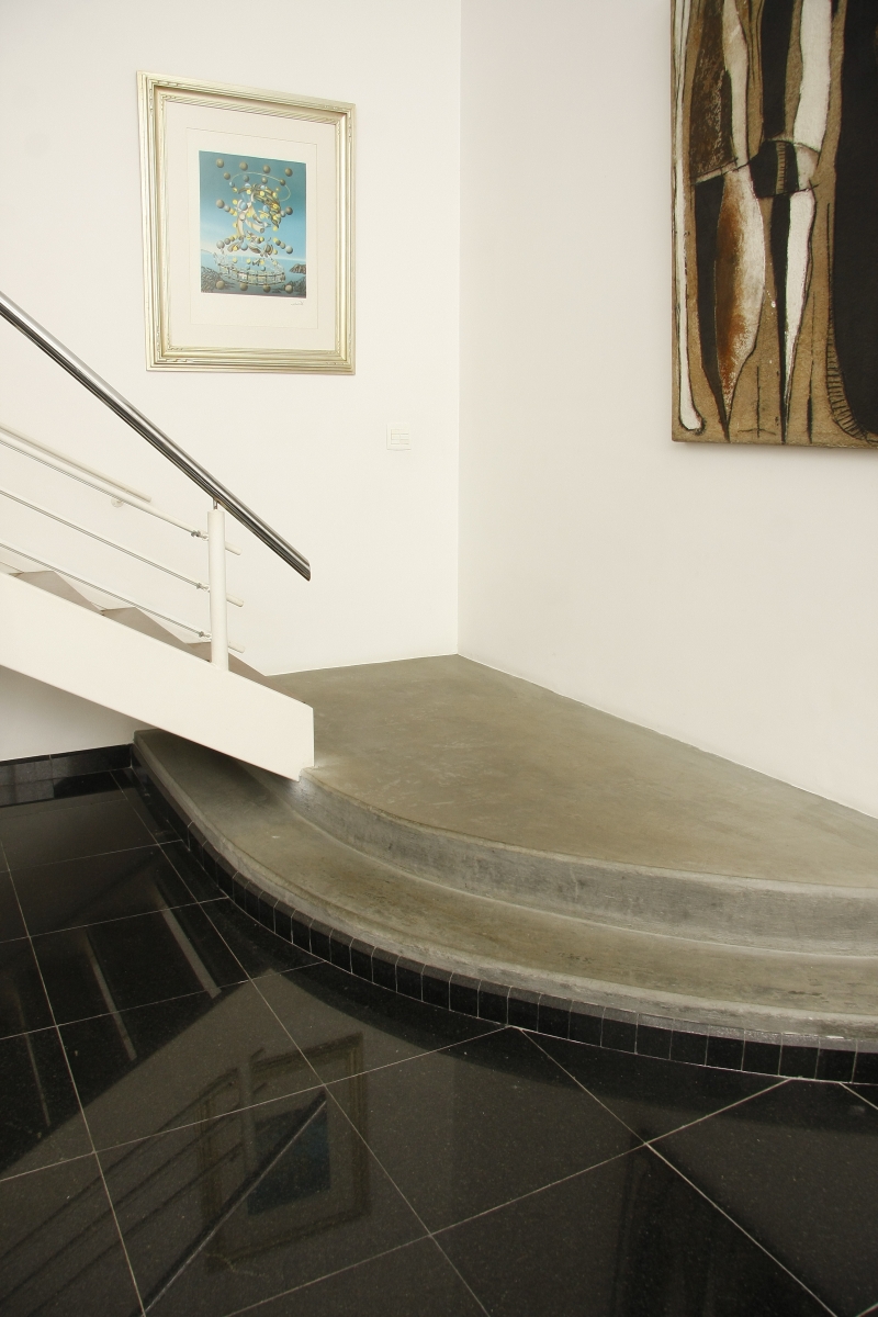 A proposta do arquiteto Gastão Lima para o patamar de convite intercala o cimento queimado com outros materiais, como o piso em granito, criando um contraste entre o rústico e o sofisticado | Hugo Harada/Gazeta do Povo
