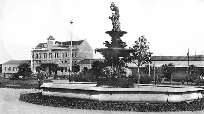 PRAÇA EUFRÁSIO CORREIA Também conhecida como a Praça da Estação. Até a sua urbanização, em 1914, por Cândido de Abreu, era um descampado, tendo ao lado o prédio da Assembleia Legislativa, hoje Câmara Municipal. Em seu enorme espaço, em 1903, foi instalada a Exposição Comemorativa do Cinquentenário do Paraná. A praça foi ornada por um belo repuxo trabalhado e que lá está desde 1915. Em 1922, comemorando o Centenário da Independência, a colônia polaca ofereceu o Monumento do Semeador, obra magnífica do escultor João Zaco Paraná. A foto é de 1915 | 