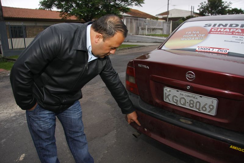 Anderson Teixeira, candidato à presidência do Sindimoc, mostra tiro que atingiu seu carro | Hugo Harada / Agência de Notícias Gazeta do Povo