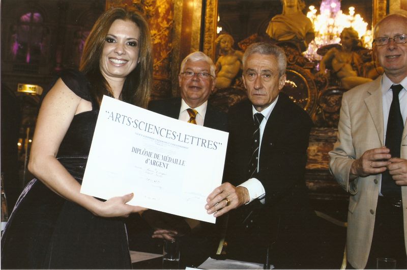 A artista plástica Simone Campos acaba de voltar de Paris, onde foi receber o diploma da Academie Arts-Sciences-Lettres da capital francesa. O evento ocorreu no Hotel Intercontinental tendo como patrono o presidente Nicolas Sarkozy. Simone recebeu o diploma das mãos do presidente da academia, Jean-Paul de Bernis (à dir.) | Mauro Campos