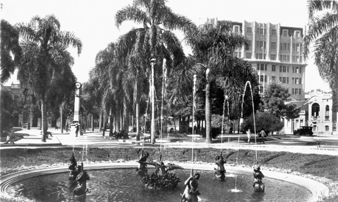 PRAÇA GENERAL OSÓRIO A fotografia é de 1934. Em primeiro plano vemos o repuxo ainda abaixo do nível do solo. Vinte anos antes, a praça foi reurbanizada por Cândido de Abreu  sendo instalado um coreto, um relógio e o citado repuxo, com as figuras de sereias jorrando água. O coreto deteriorou-se e foi demolido em fins de 1950. O relógio mal funcionava e foi substituído por outros tipos; e, finalmente, o repuxo foi reformado e suas figuras foram elevadas, no início dos anos sessenta, pelo prefeito Iberê de Mattos | 