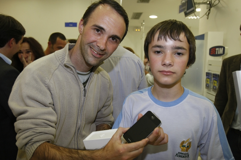 André e Victor Sluzala, com o brinquedinho recém-comprado: o menino ficou com o iPhone 3GS do pai, que migrou para a nova versão do aparelho | Pedro Serápio/ Gazeta do Povo
