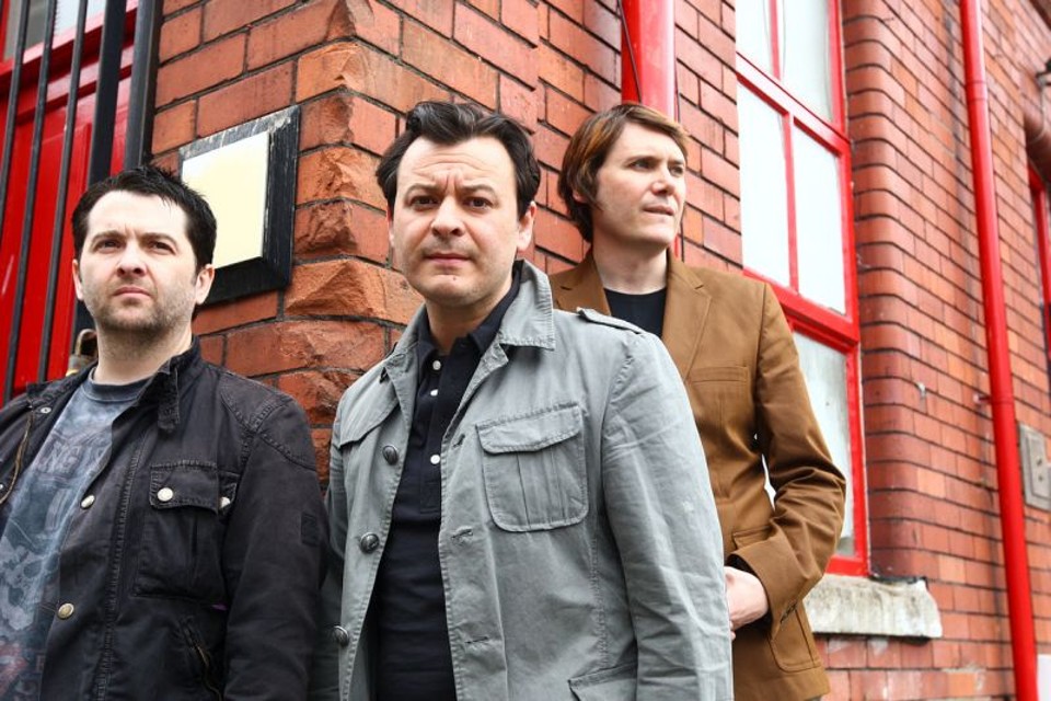 Enfim, a revolução para os Manics Sean Moore, James Dean Bradfield e Nick Wire: Manic está mais leve e conformado | Divulgação