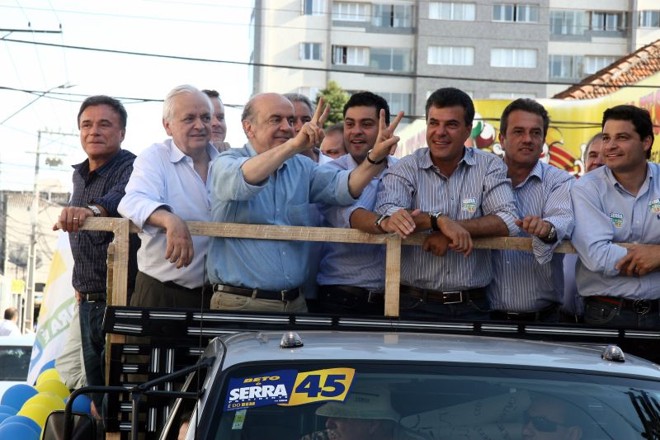 José Serra em campanha em Ponta Grossa: carroceria cheia de aliados e carro circulando em área de pedestres |