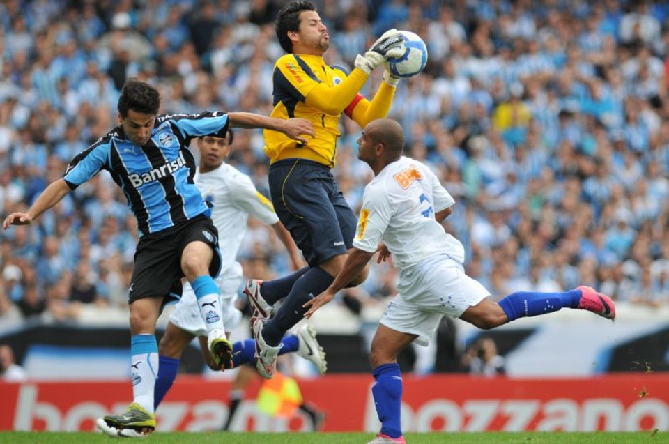 Grêmio 2 X Cruzeiro 1 Jonas, do Grêmio, artilheiro do Brasileirão, divide a bola com o goleiro Fábio: mesmo com a derrota, Cruzeiro segue líder | Camila Domingues/Correio do Povo