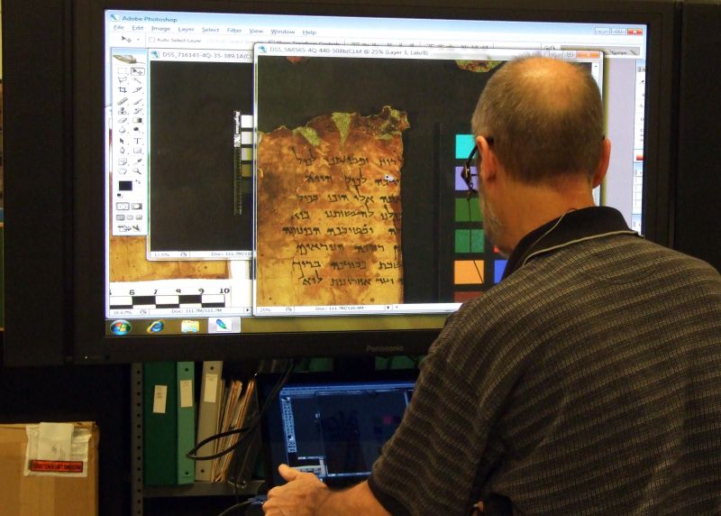 Pesquisador trabalha com cópia de manuscrito, em Jerusalém | AFP