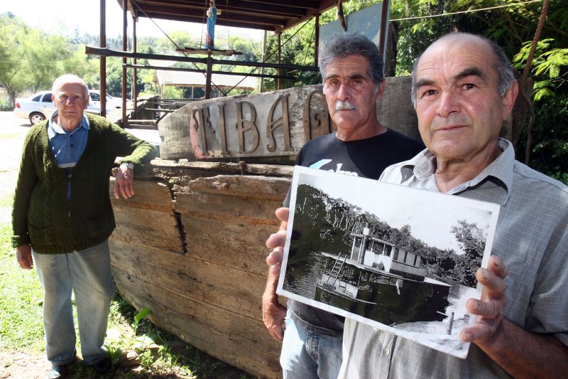 José (com a foto do Tibagi em funcionamento) e Renato retiraram parte do vapor do Rio Iguaçu. Ao fundo, Antônio, que fazia a limpeza do barco | Hewnry Milleo/Gazeta do Povo