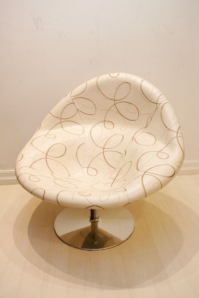 Estampas bordadas na poltrona do tipo concha, em couro ecológico, da Studio Casa. Preço sob consulta | 