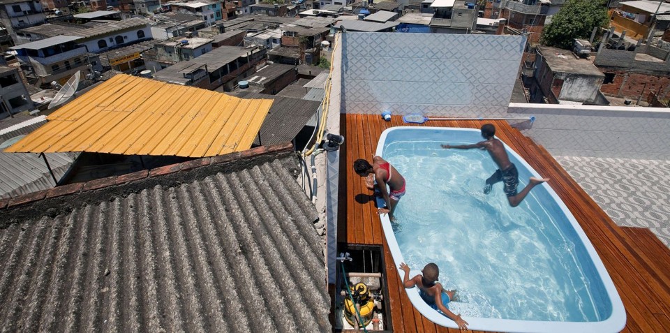 Luxo e estravagância: casa de traficante no morro tem piscina e até uma discoteca. Crianças brincam no local após a ocupação da polícia. | Jefferson Bernardes - AFP