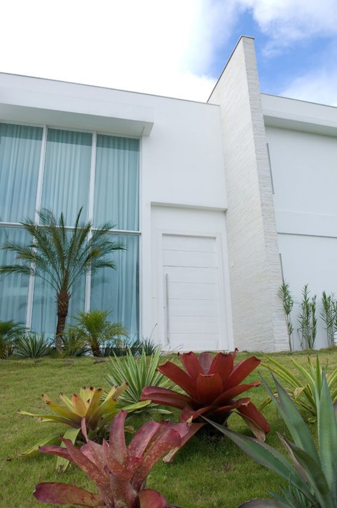 No projeto de Andréa Benthien, o detalhe em madeira na vista acima da porta de 2,70 metros dá à estrutura a sensação de ser ainda mais alta | 