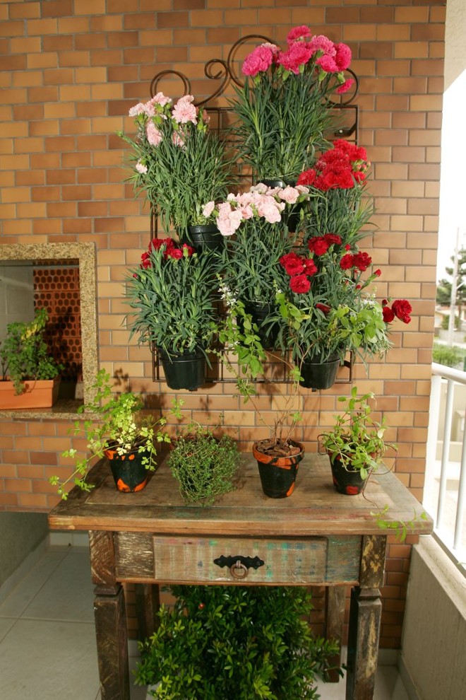 Jardins e hortas verticais -A verticalização é a opção para quem faz questão de ter um pouco de verde em casa. Pode ser em cachepô, em vasos ou suportes de vasos. Podem ser usadas cruzetas de madeira de demolição para prender os vasos, orienta a arquiteta Ana Paula Zordan. Ela tem na área de churrasqueira de casa um modelo, nesse caso preso a uma armação de ferro. Tenho vasinhos com vários temperos, que ficam bonitos com flores ou plantas também. | Antonio More/Gazeta do Povo