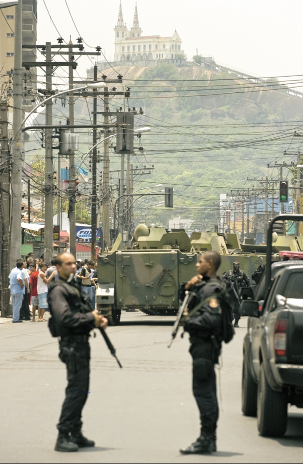 Com a Igreja da Penha ao fundo, policiais se preparam para a operação: tanques da Marinha foram fundamentais na vitória | Antonio Scorza / AFP