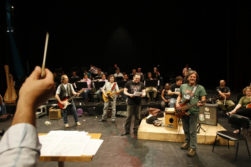 Sob a batuta do maestro Alessandro Sangiorgi, o Blindagem ensaia com o vocalista Rodriggo Vivasz (ao centro, de preto) e a Orquestra Sinfônica | Daniel Castellano/Gazeta do Povo