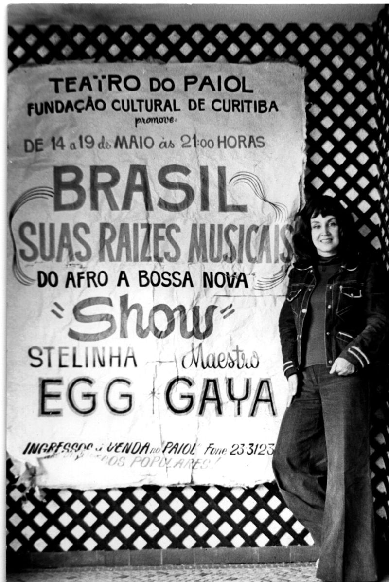 Stelinha posa ao lado de um cartaz de uma temporada de shows em Curitiba | Arquivo do MIS/Divulgação