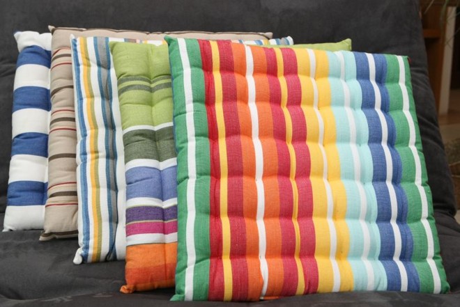 Pequenos futons coloridos, no formato de almofadas. Preço: R$ 59 cada, na Perfeito Equilíbrio |