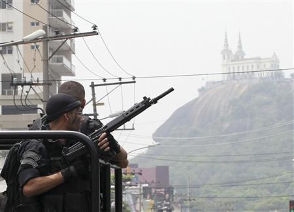 Policiais patrulham a rua durante operação na favela Vila Cruzeiro, no Rio de Janeiro, 25 de novembro de 201 | Reuters