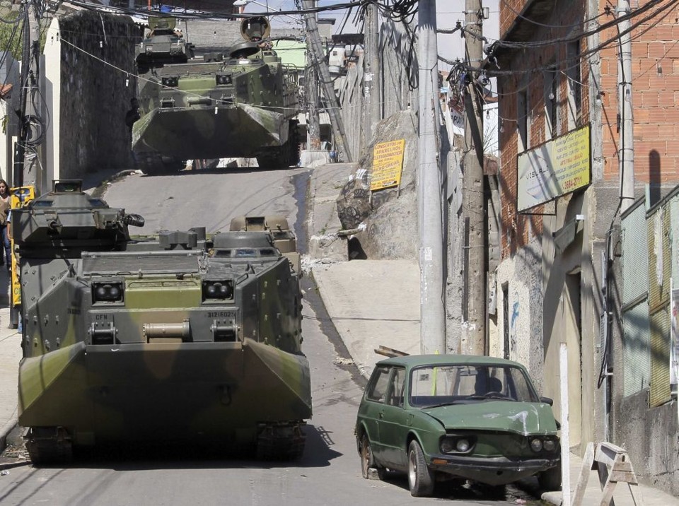 Cenário de guerra - Blindados M113 da Marinha abriram caminho para os policiais militares e civis que subiram o morro no Complexo do Alemão. As máquinas de guerra superaram facilmente os obstáculos deixados por traficantes e, a exemplo da ocupação da Vila Cruzeiro, foram determinantes para a vitória policial. Segundo o governador Sérgio Cabral, o Exército deve fazer a segurança no Alemão até a chegada de uma UPP | Sérgio Moraes/Reuters