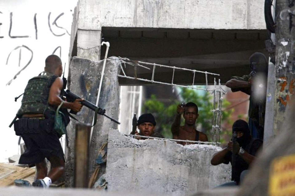 Traficantes armados se exibem para fotógrafos em uma casamata na favela da grota: polícia estima que há pelo menos 500 traficantes no Complexo do Alemão | Tiago Cardoso/AFP