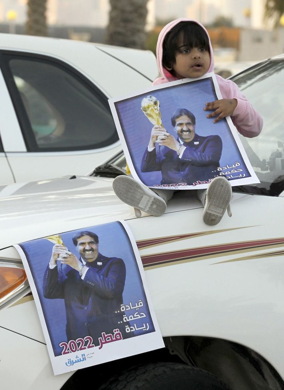 Fifa administra onda de revolta na eleição Criança mostra foto do xeque Hamad Al Thani um dia depois de o Catar ser escolhido para sede da Copa de 2022 | Fadi Al-Assaad/ Reuters