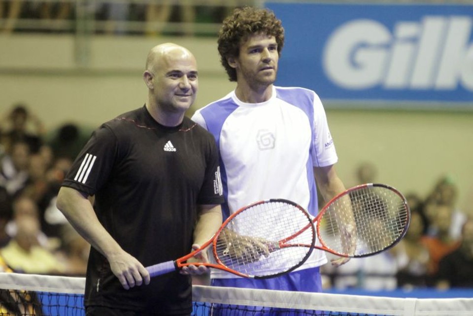 Festa de Guga termina com show de rock O norte-americano Andre Agassi ao lado de Gustavo Kuerten, após o jogo amistoso que festejou os 10 anos da chegada ao topo do ranking pelo brasileiro. Brasileiro se emocionou com as homenagens | Bruno Domingos/ Reuters