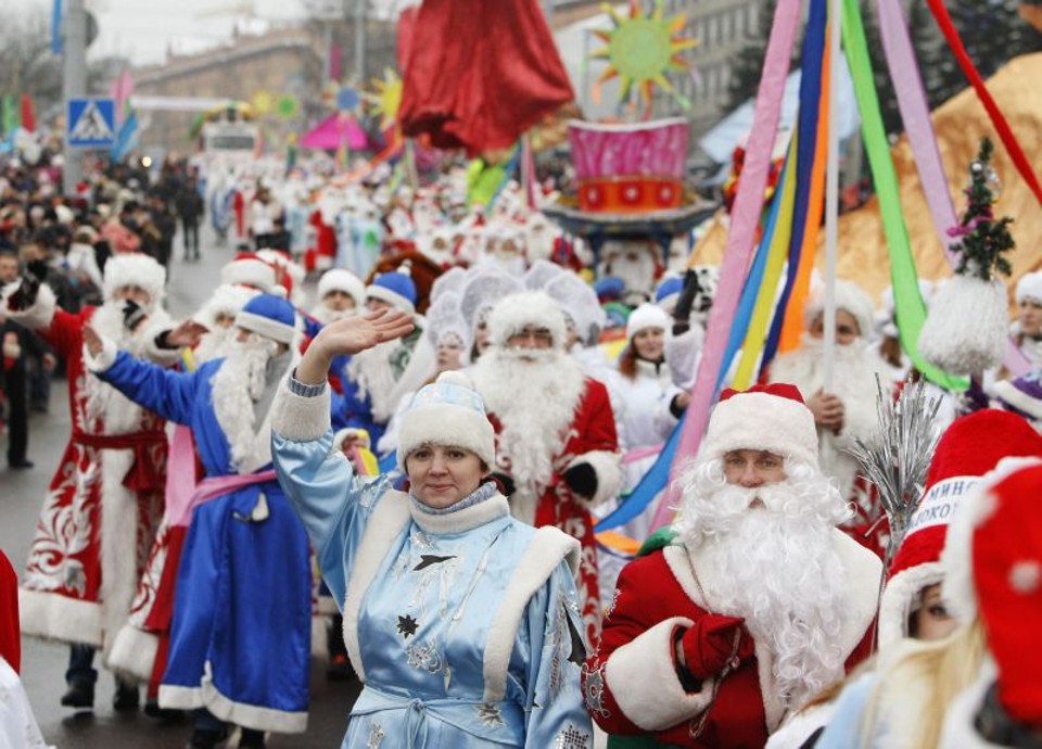 Cerca de 600 pessoas vestidas como Papai Noel e Mamãe Noel participam da procissão pela praça central em Minsque, na Bielorússia | Fedosenko Vasily / Reuters