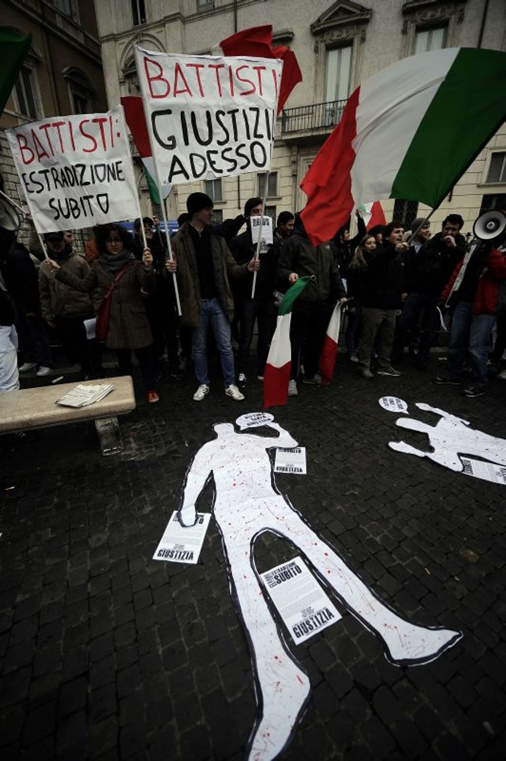 Manifestantes, durante protesto contra a recusa do Brasil de extraditar Battisti, em 4 de janeiro: figura de um corpo estendido no chão, em frente da embaixada brasileira em Roma, simboliza as vítimas do italiano