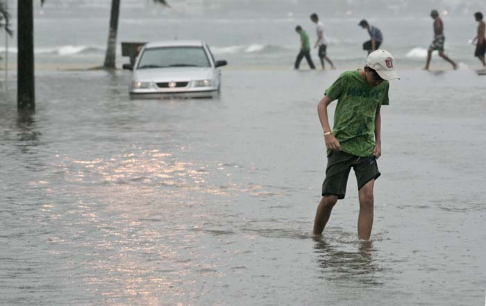 Moradores se ariscaram atravessando as ruas alagadas em Guaratuba | Priscila Forone/Agência Notícias Gazeta do Povo