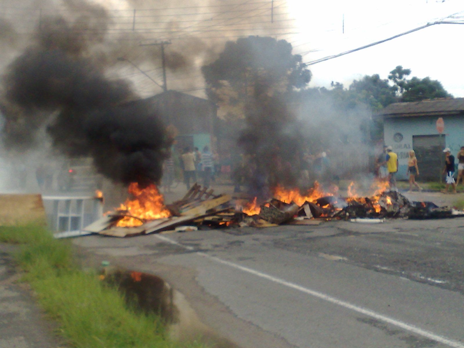 Os moradores levaram os móveis destruídos pela chuva para o meio da rua e atearam fogo | Aniela Almeida/Agência de Notícias Gazeta do Povo