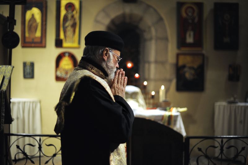 Padre copta religião cristã do Egito reza missa em Dijon, na França: ataques em Alexandria fizeram 23 mortos no ano-novo | Jeff Pachoud/AFP
