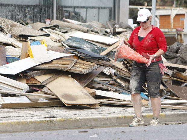Moradora avalia estragos em sua loja em Ipswich, a 40 km de Brisbane, nesta sexta-feira (14) | Reuters