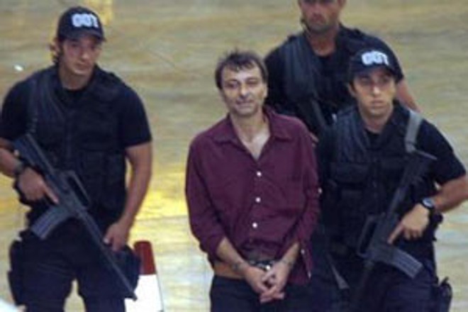O italiano Cesare Battisti conduzido por policiais federais na chegada a Brasília, em 2007 | 