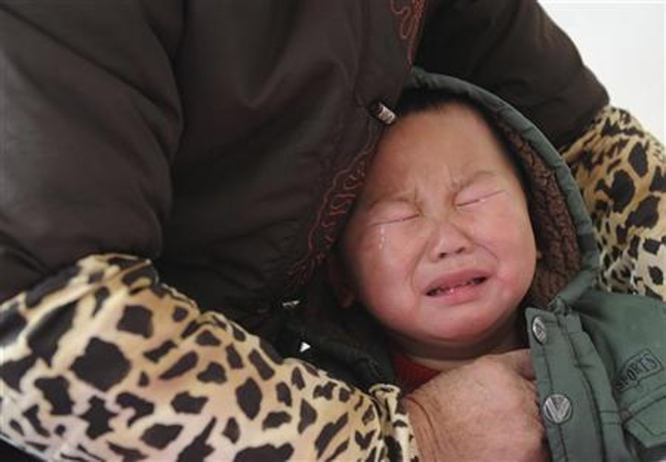Criança diagnosticada com excesso de chumbo no sangue chora ao receber tratamento médico em hospital em Hefei, na província de Anhui | Reuters