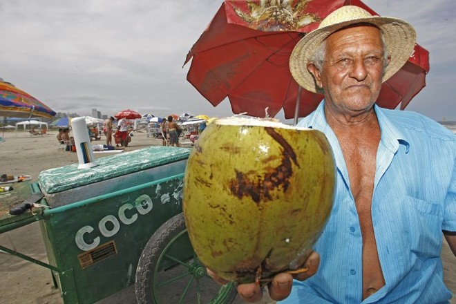 Vendedor de coco há 40 anos, Dorival Rangel Ribeiro diz que boa conversa e amizade com veranistas compensam o preço da fruta | 