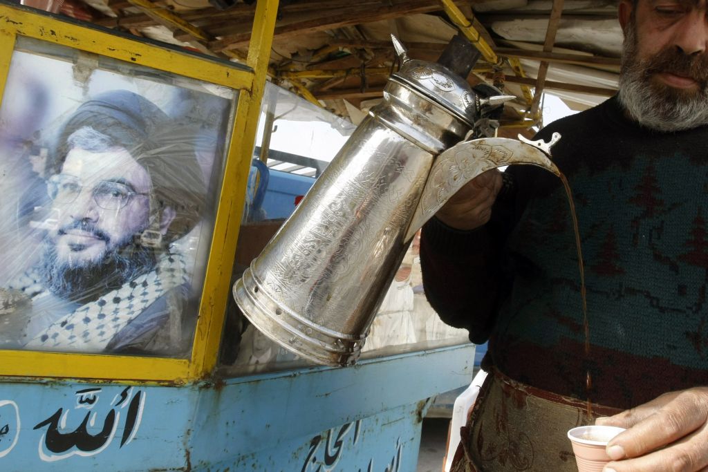 Libanês é visto servindo café: na sua barraca, uma imagem de Hassan Nasrallah, líder do Hezbollah, a maior força militar existente no Líbano e considerado grupo terrorista por EUA e Israel | AFP