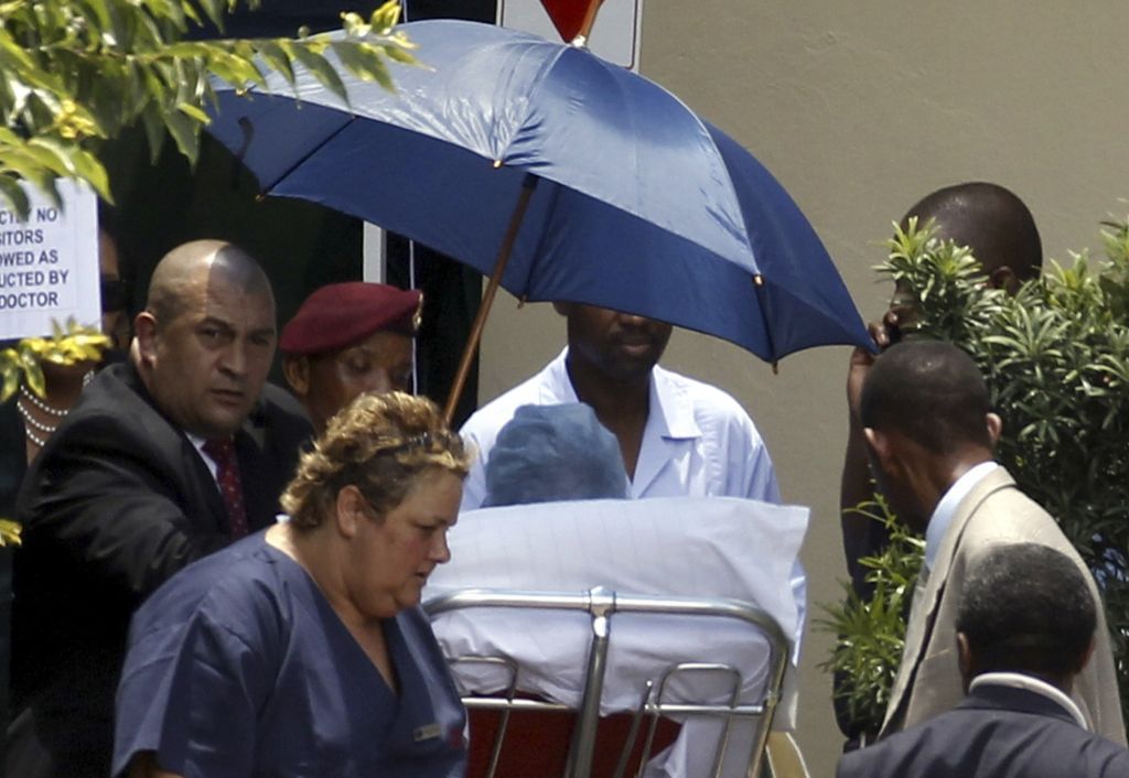 O ex-presidente Nelson Mandela sai do hospital de Johannesburgo, de maca, protegido do sol e amparado por diversas pessoas | Siphiwe Sibeko/Reuters