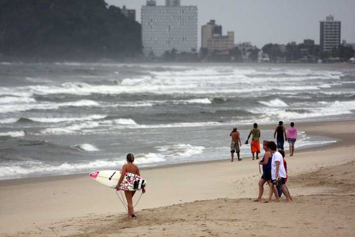 Pouca gente enfrentou o tempo instável e foi à praia na manhã desta quarta-feira. Os poucos a se assiscarem no mar foram os surfistas | Walter Alves/Gazeta do Povo
