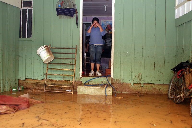 Moradora do bairro Tanguá, em Almirante Tamandaré, observa o prejuízo causado pela chuva: água invadiu casas e deixou moradores ilhados | Walter Alves/Gazeta do Povo