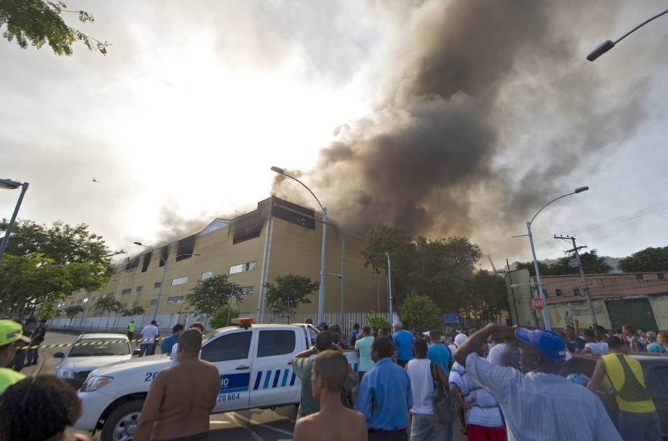 Fogo que atingiu Cidade do Samba foi controlado pelos bombeiros por volta das 11 horas da manhã. Quatro barracões foram atingidos | AFP PHOTO / ANTONIO SCORZA