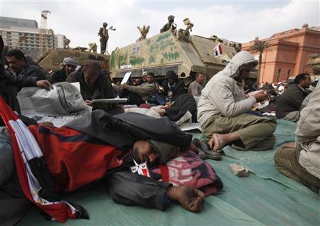 Manifestantes se aglomeram perto de tanques na praça Tahrir, no Cairo. O governo do Egito realiza nesta segunda-feira sua primeira reunião ministerial plena desde o início dos protestos contra o presidente Hosni Mubarak, sem sinais de progressos por enquanto no diálogo com a oposição, que deseja a saída imediata dele | REUTERS/Asmaa Waguih