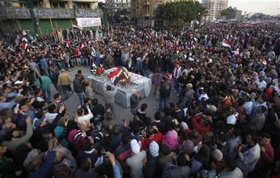 Membros da oposiçãoo se reúnem em volta de túmulo para vítimas dos confrontos na praçaa Tahrir, no Cairo | Reuters