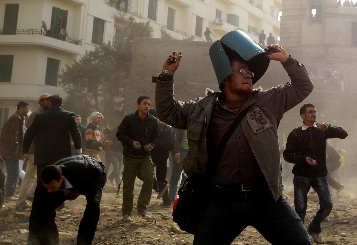 Um manifestante da oposição atira pedra durante confronto com seguidores do presidente egípcio, Hosni Mubarak, perto da praça Tahrir, no Cairo | REUTERS/Goran Tomasevic