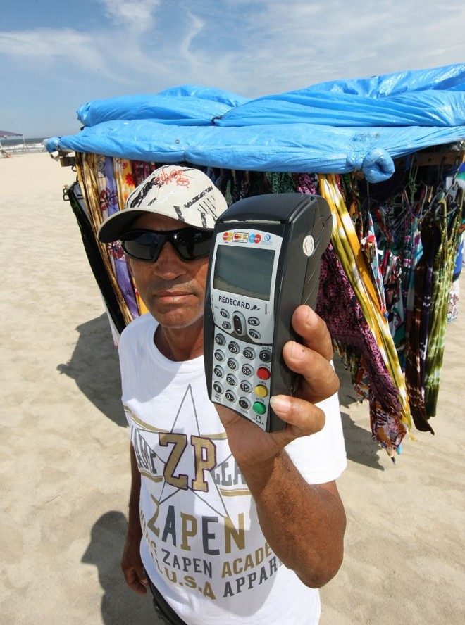 O ambulante Roberto Gomes aceita cartões de crédito e débito para as compras feitas na areia e não perde mais clientes | 