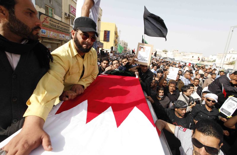 O corpo de um protestante morto é levado para o cemitério numa marcha com familiares e simpatizantes, em Manama | Hamad I Mohammed/Reuters