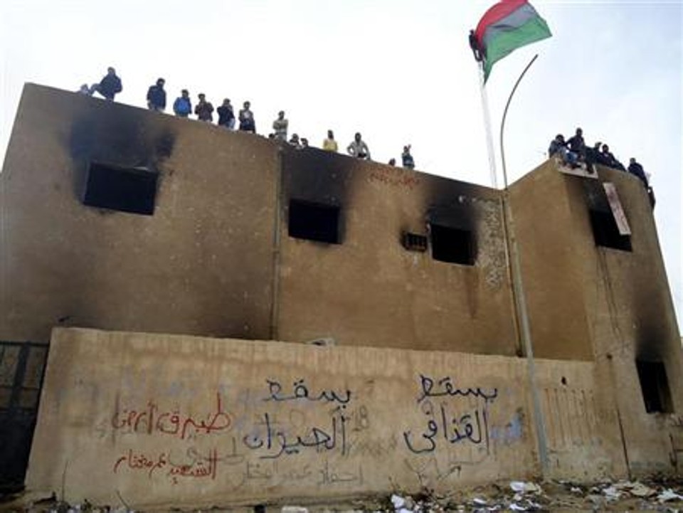 Manifestantes líbios ocupam o topo de um edifício durante uma manifestação na cidade portuária de Tobruk, na Líbia | REUTERS/Stringer